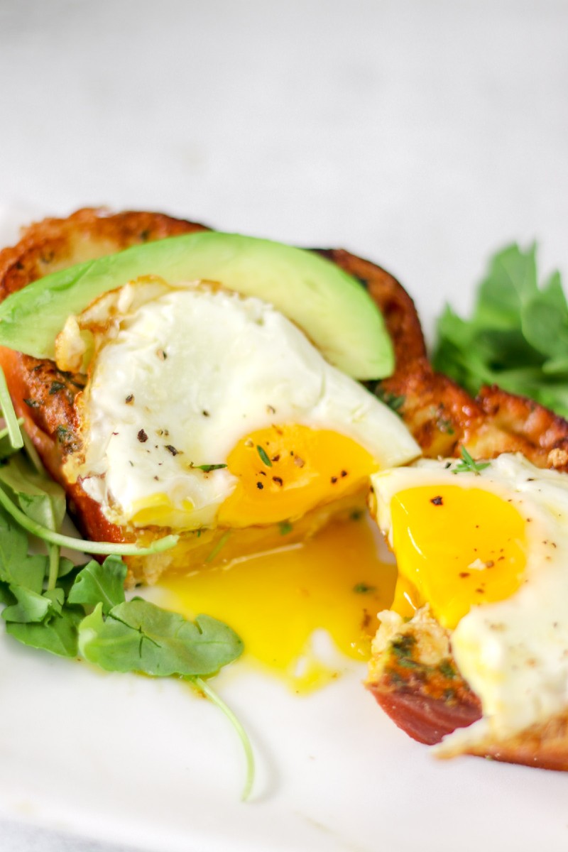 image of runny egg on a bread slice with greens