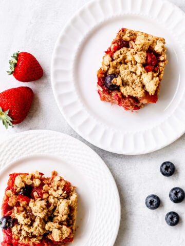 Sliced mixed berry crumble bars on parchment paper showing jammy blueberry and raspberry filling