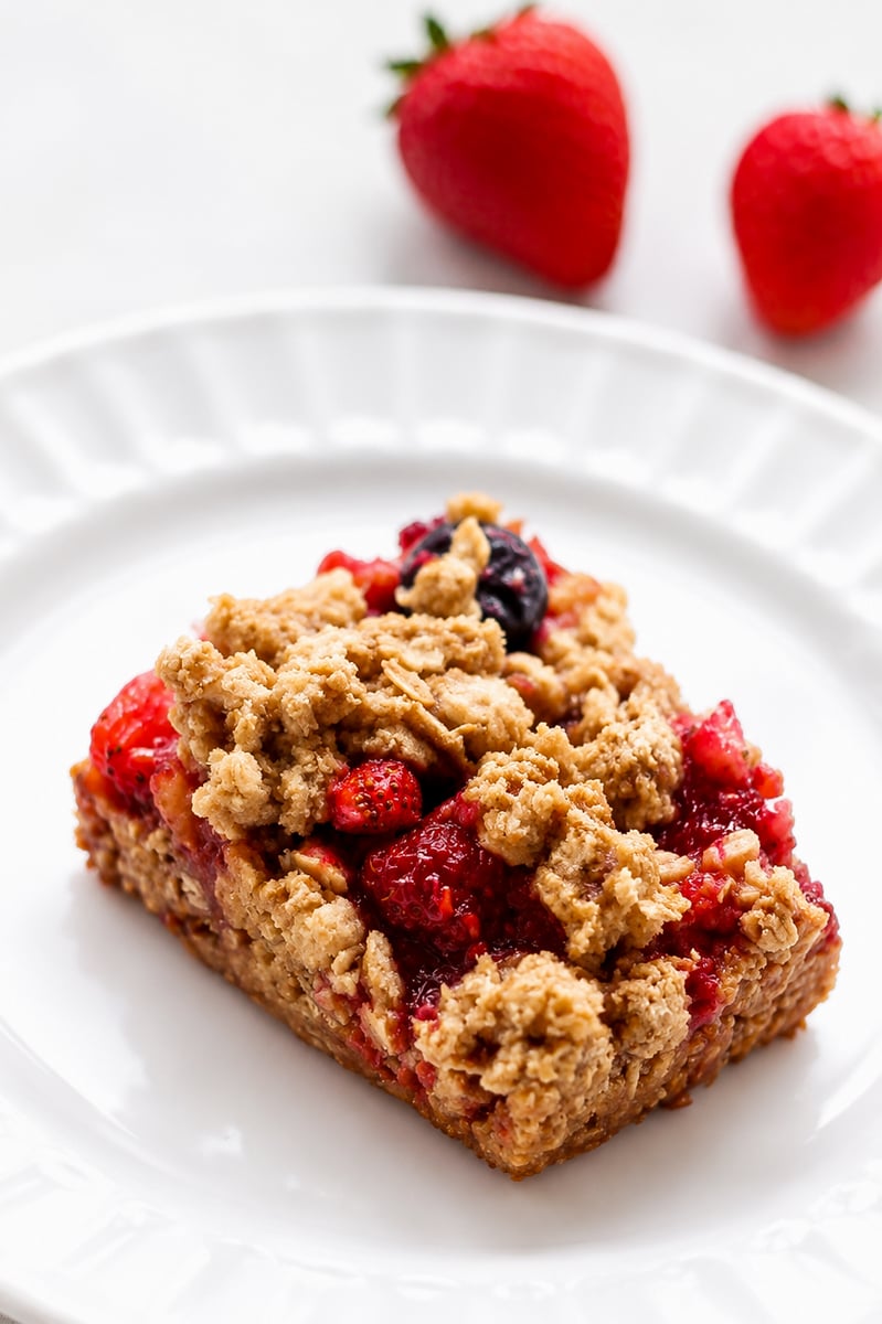 Sliced mixed berry crumble bars on parchment paper showing jammy blueberry and raspberry filling