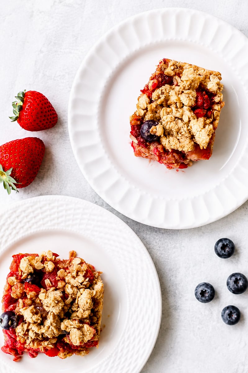 Sliced mixed berry crumble bars on parchment paper showing jammy blueberry and raspberry filling
