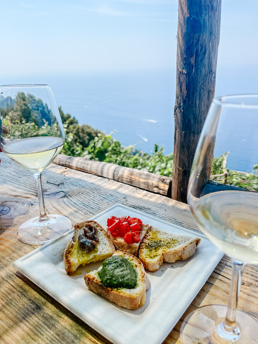 image of food on plates and wine overlooking the sea