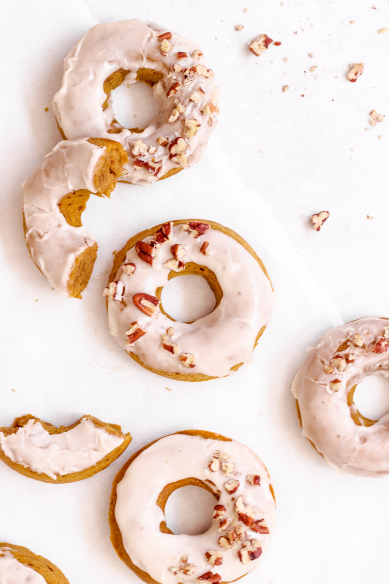 overhead image of baked pumpkin spice donuts with a maple glaze