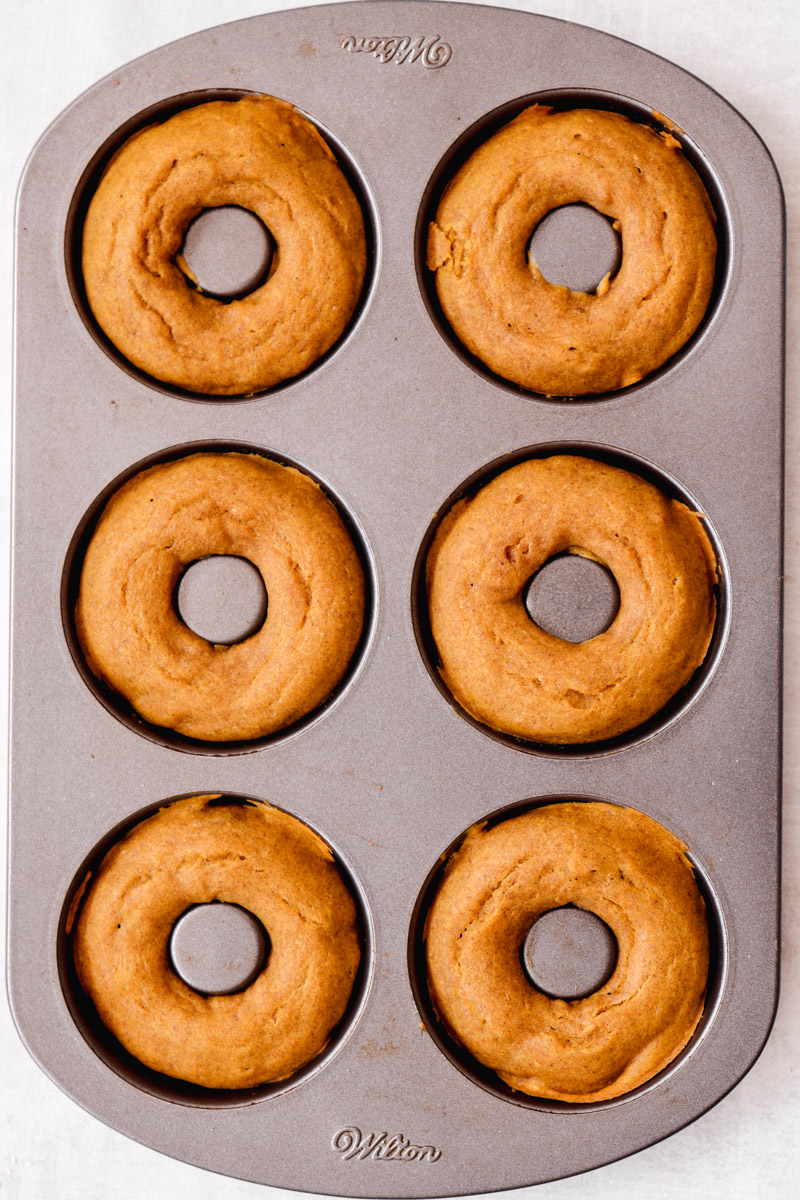 overhead image of baked donuts in a baking pan
