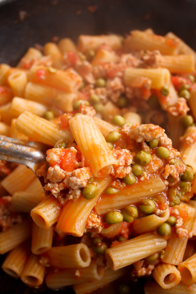 overhead image of Sicilian pasta with ground chicken and peas in a skillet