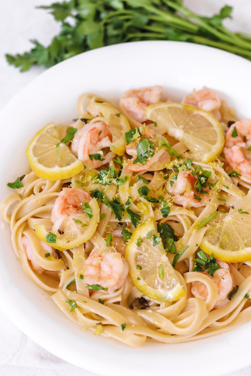 overhead image of shrimp scampi with linguine on a white plate