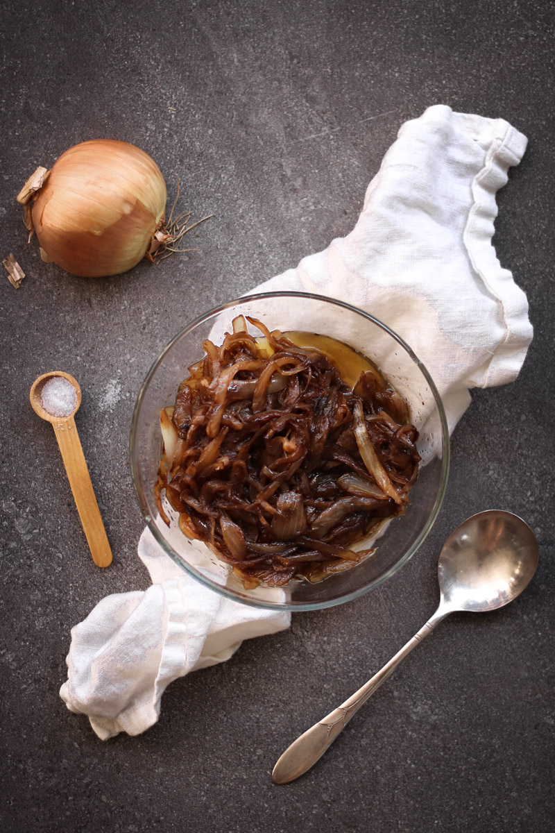 overhead image of easy caramelized onions with white napkin and onion in background