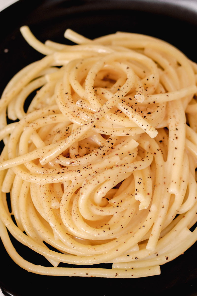 cacio e pepe on a black dish