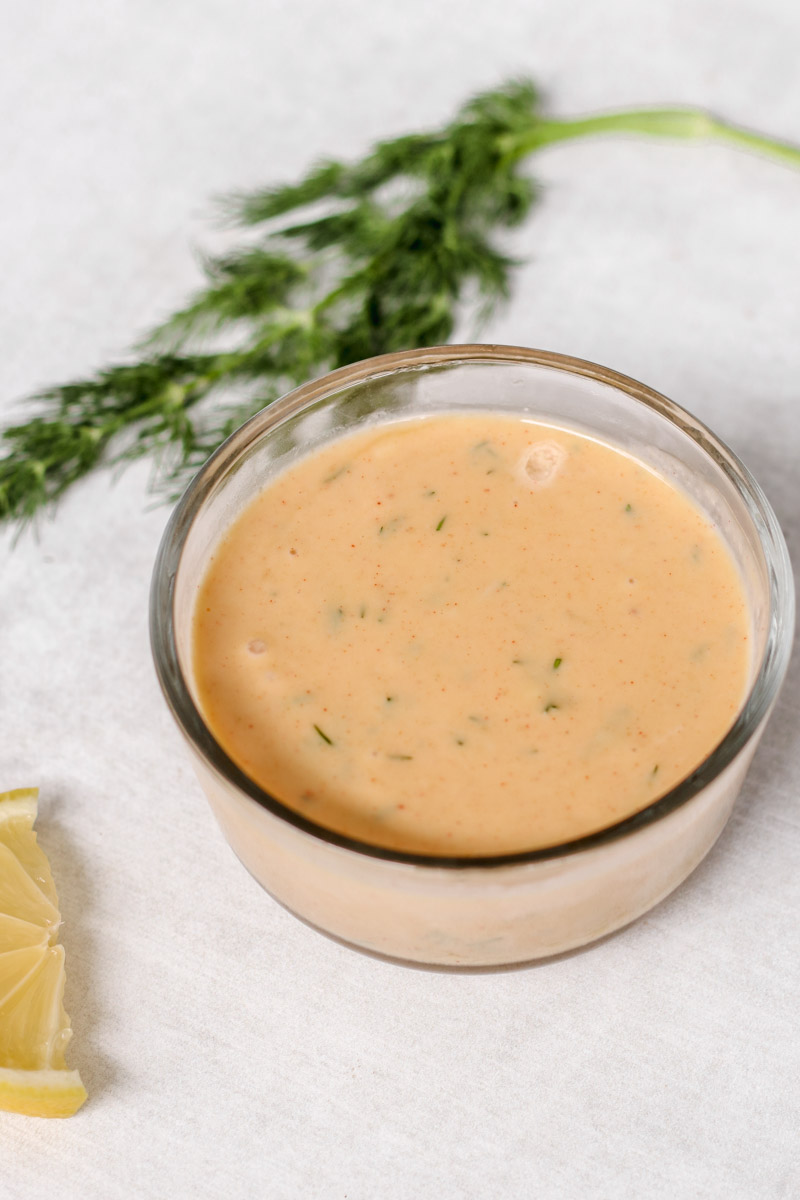 overhead image of mustard sauce and fresh dill in the background 
