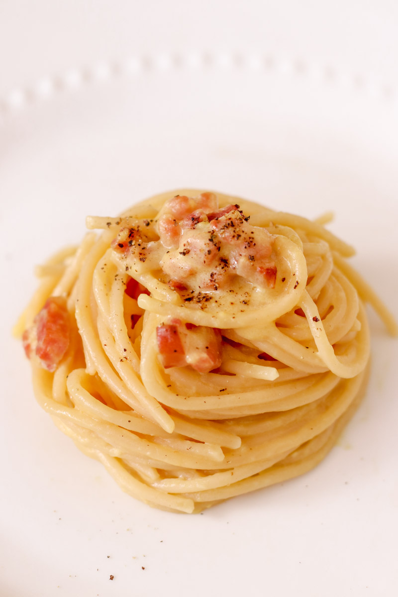 closeup mage of spaghetti alla carbonara on a white plate