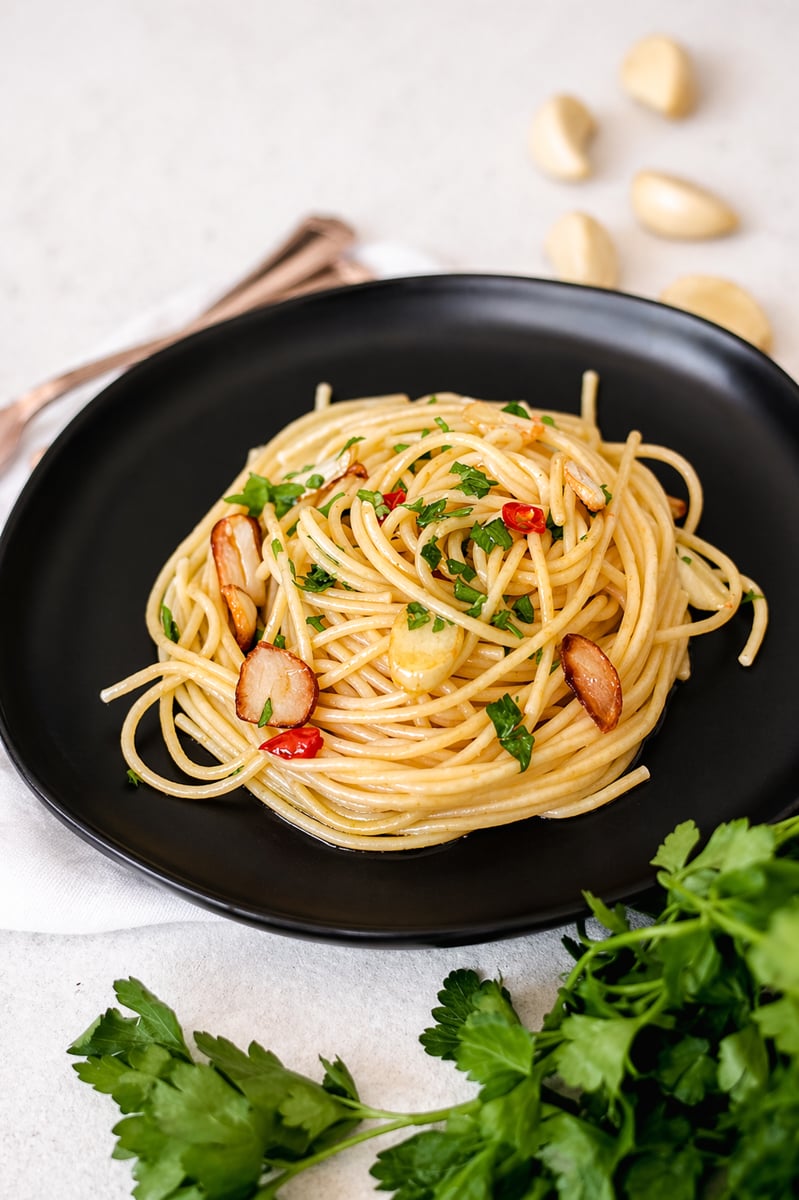 Authentic aglio e olio in a white pasta bowl topped with parsley