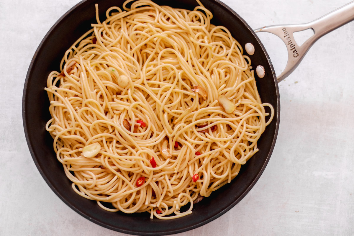 overhead image of spaghetti aglio e olio in a large skillet. 