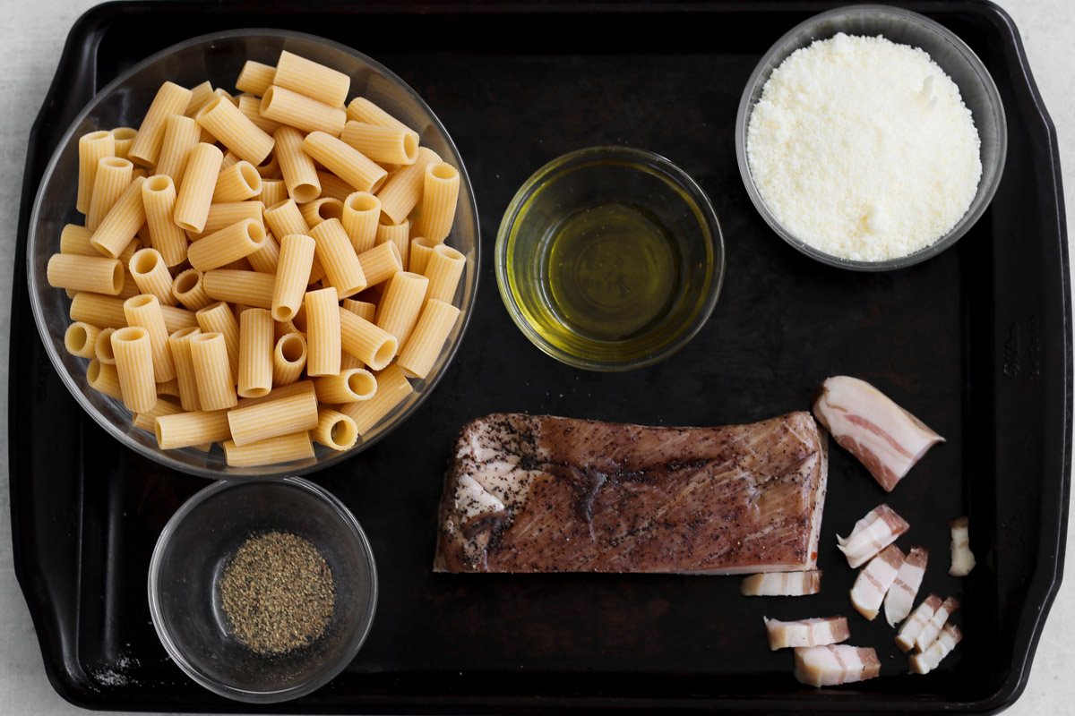 overhead image of ingredients to make pasta alla gricia on a pan. 