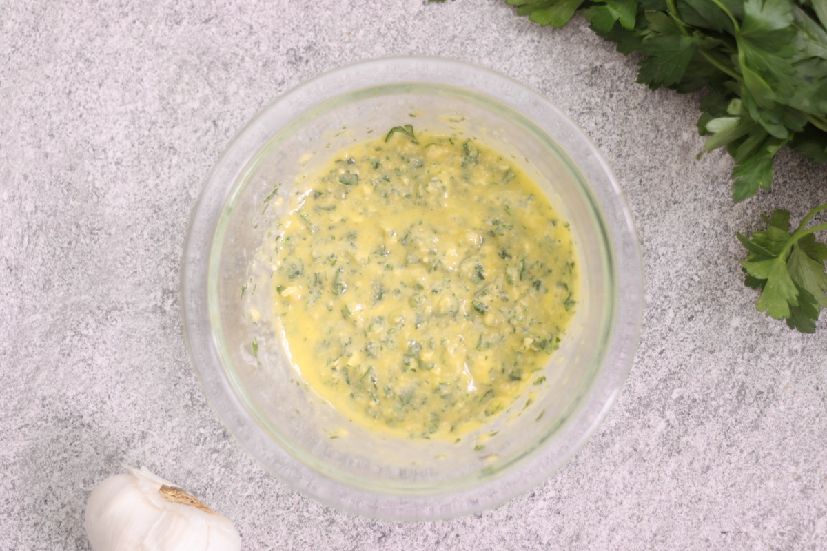 overhead image of garlic butter in a glass bowl.