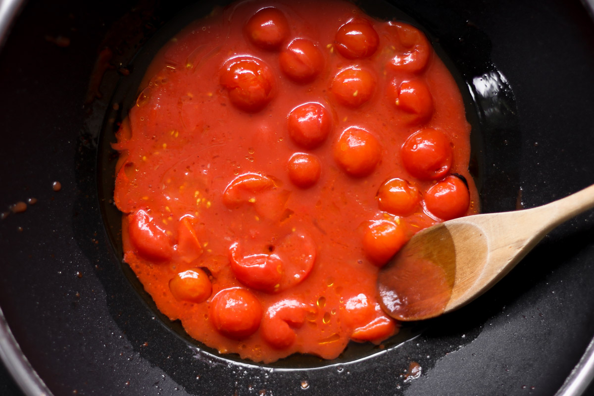 overhead image of cooking cherry tomatoes in pan. 