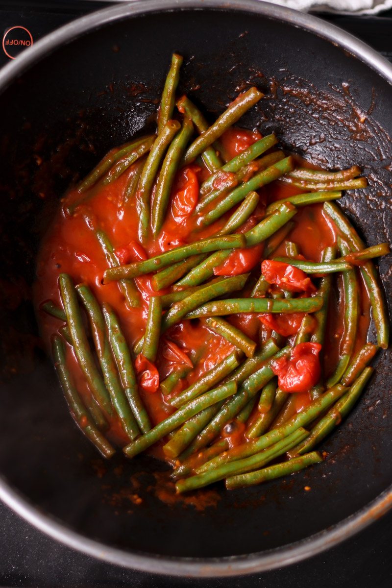 overhead image of green beans in tomato sauce. 