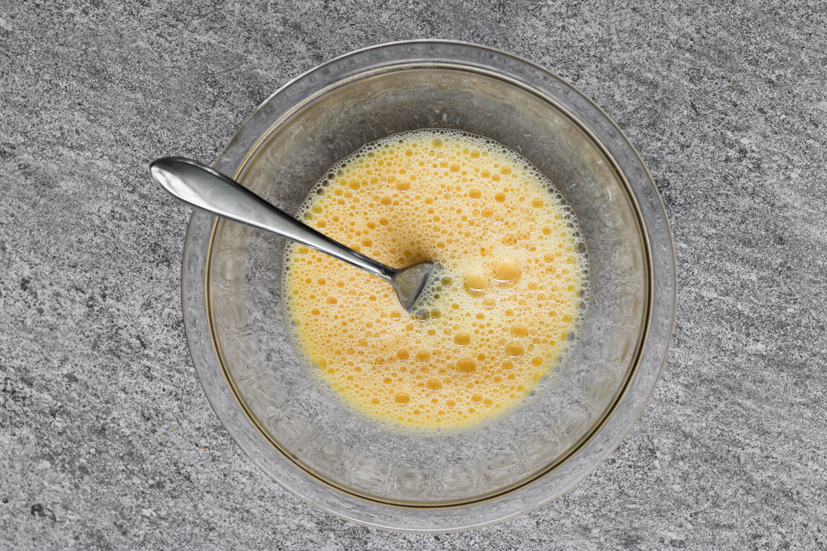 overhead image of egg wash in a glass bowl. 