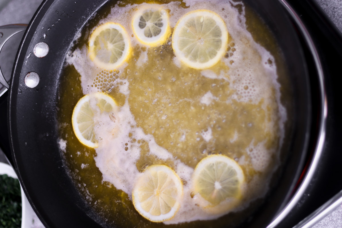 overhead image of making lemon butter sauce with lemon slices. 