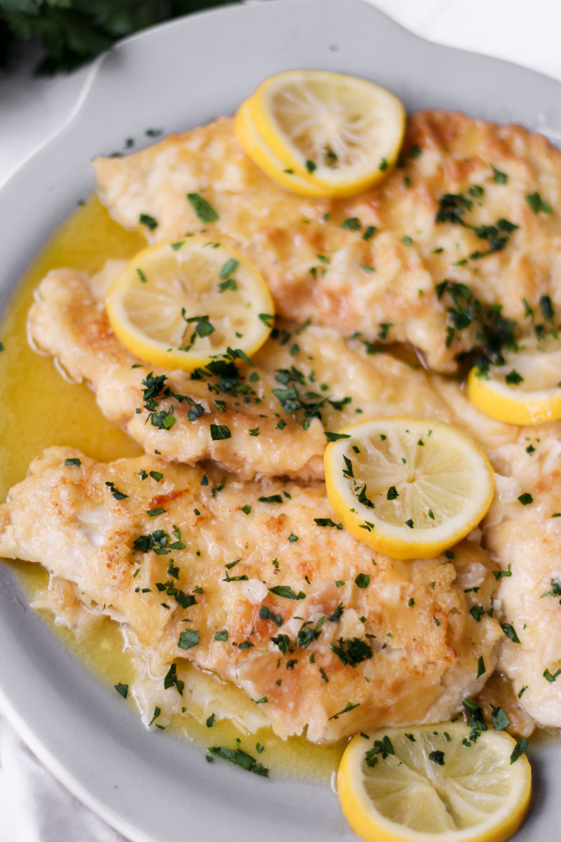 Lemon chicken in the best lemon butter sauce on a grey serving dish.