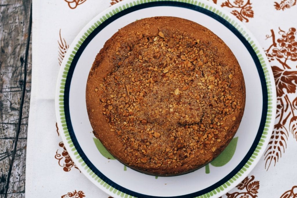 overhead image of an easy apple sour cream cake on a white and green plate.