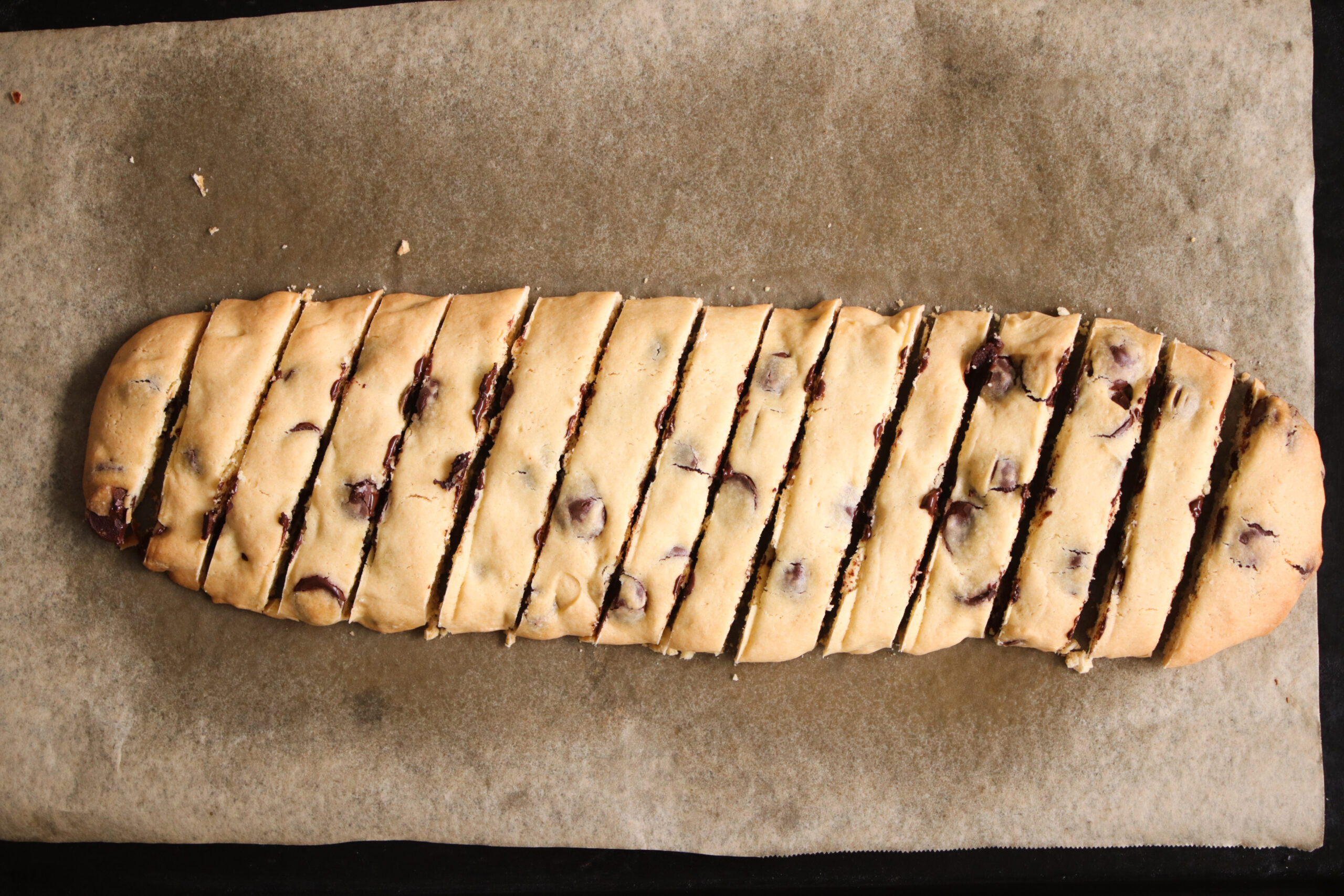 overhead image of sliced biscotti log on a baking tray.