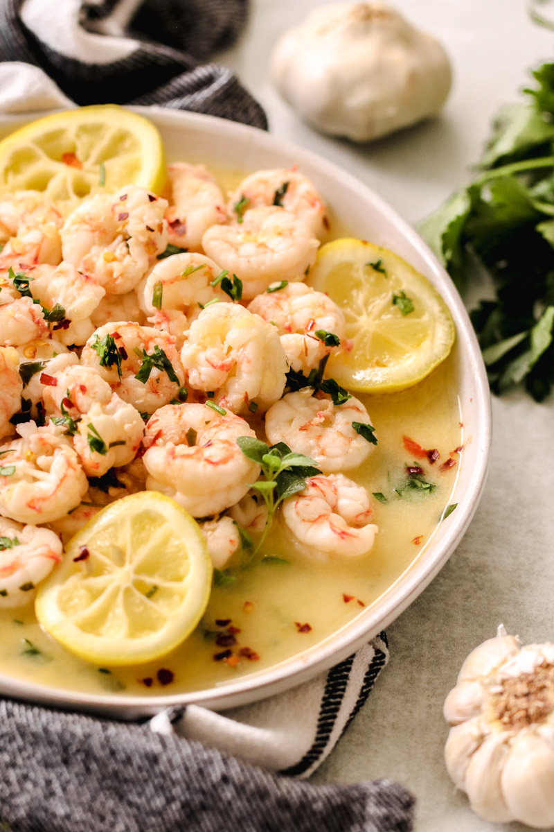 overhead image of garlic butter shrimp on a white plate. 