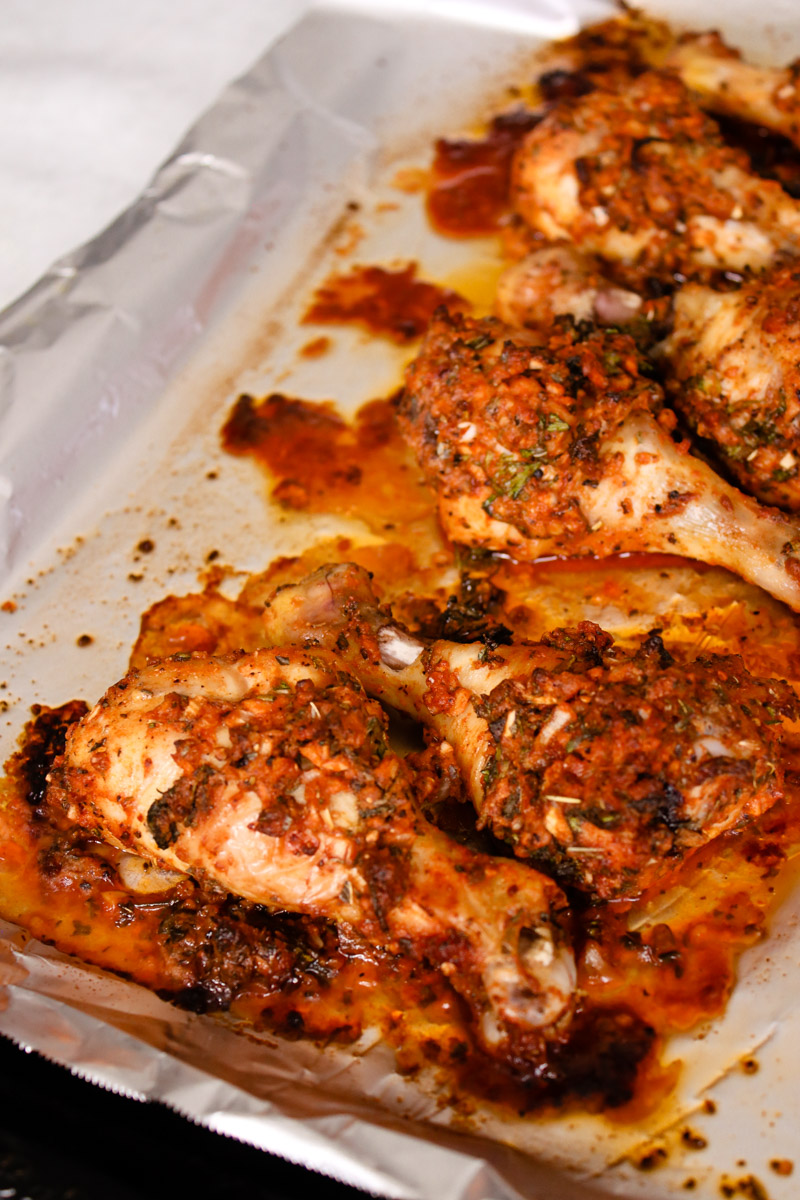 close up image of chicken legs on a baking sheet.