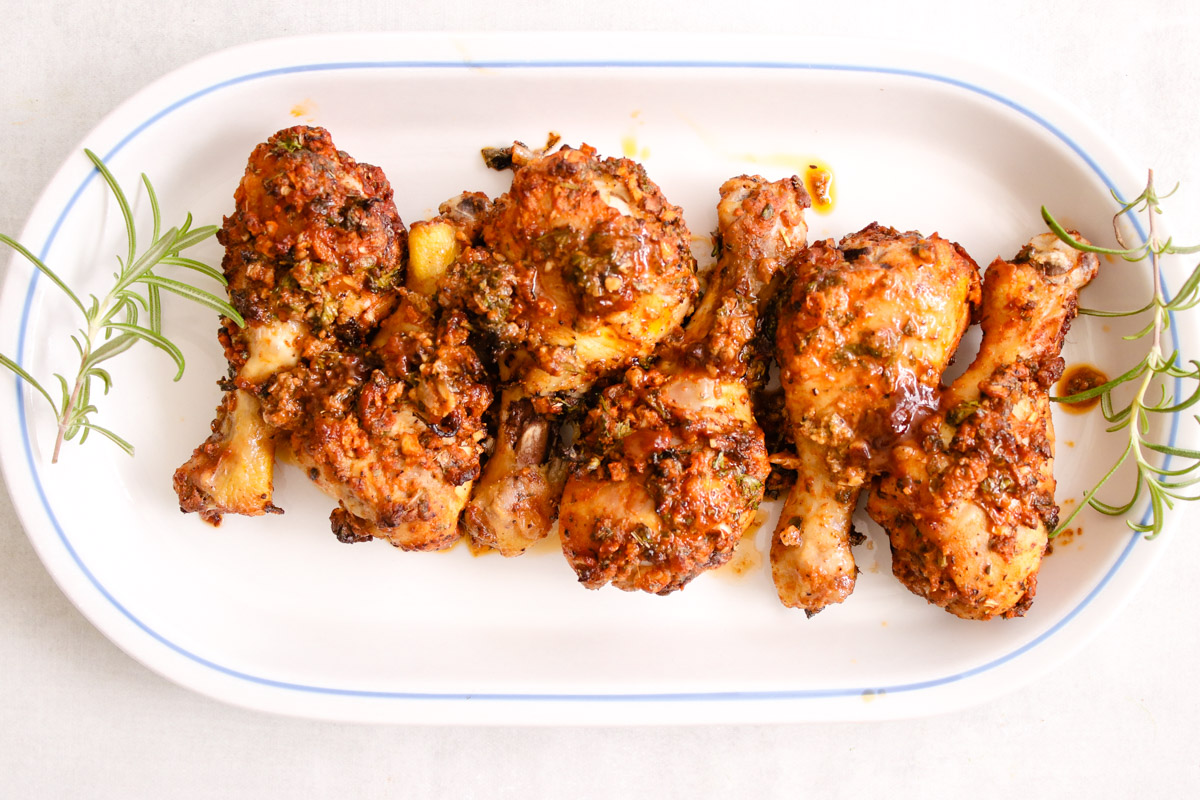 overhead image of chicken legs on a white plate. 