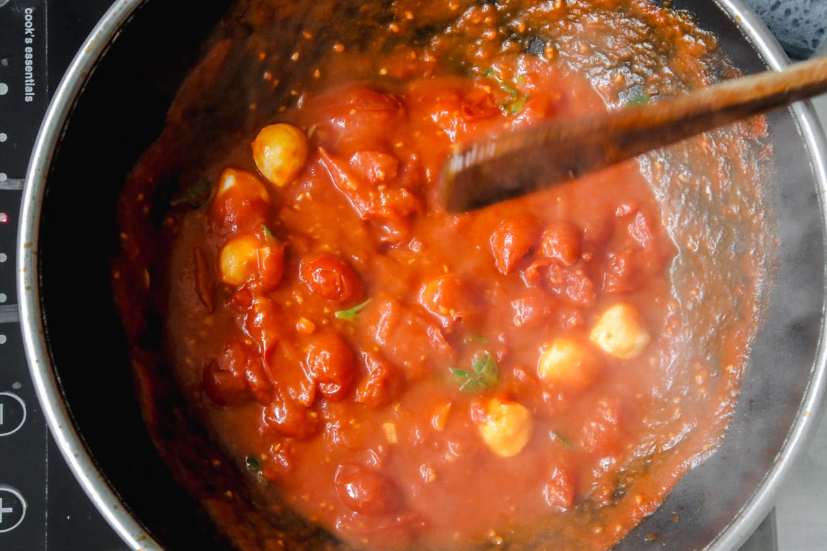 overhead image of making tomato sauce in a skillet.