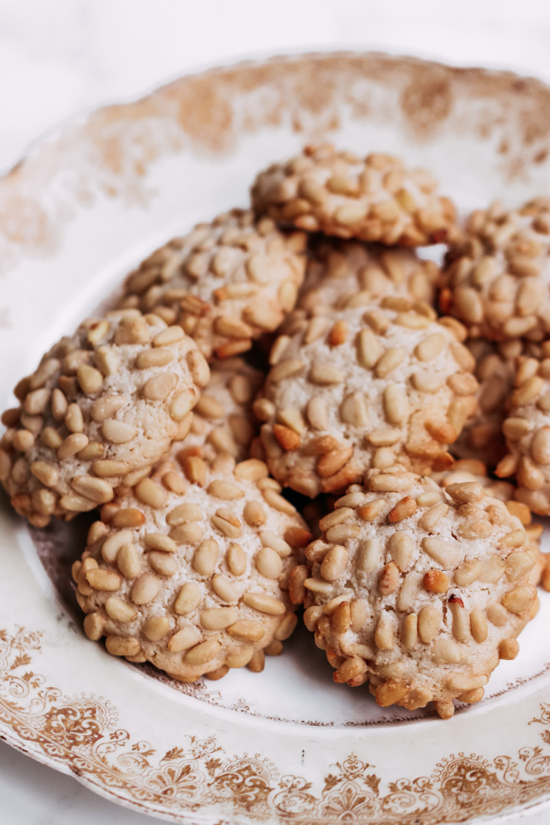 close up image of pignoli cookies on a serving dish. 