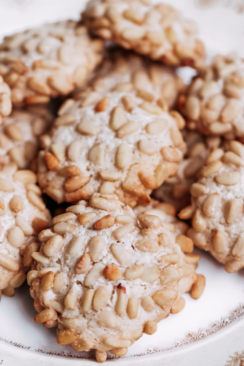 close up image of pignoli cookies on a serving dish.