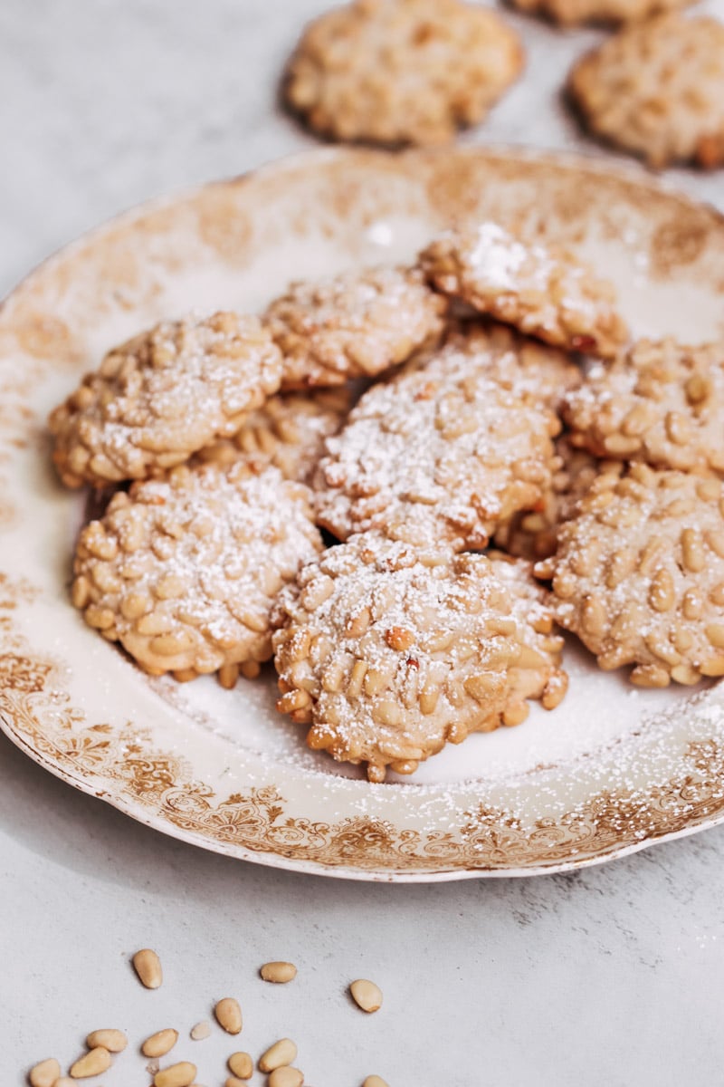 close up image of pignoli cookies on a serving dish.