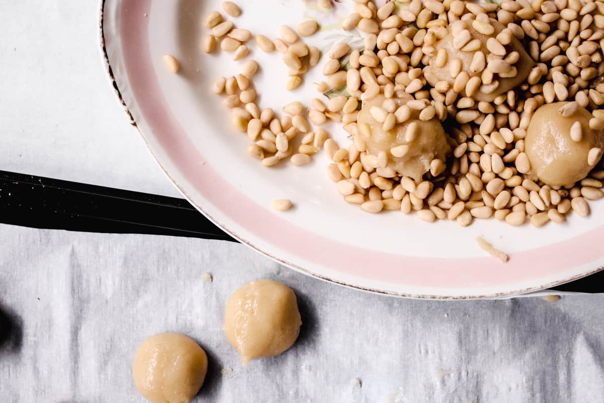 making pignoli cookies on a serving dish.