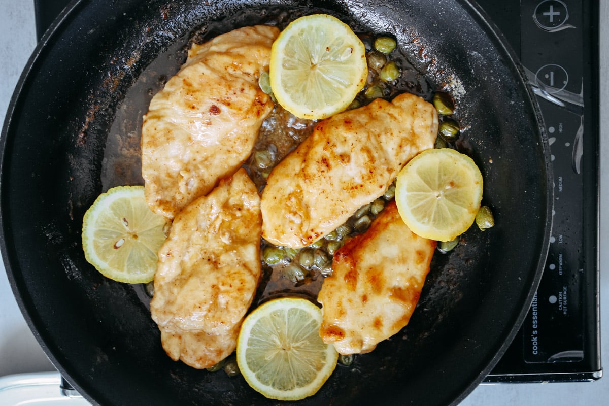 overhead image of cooking chicken breast in a lemon sauce.