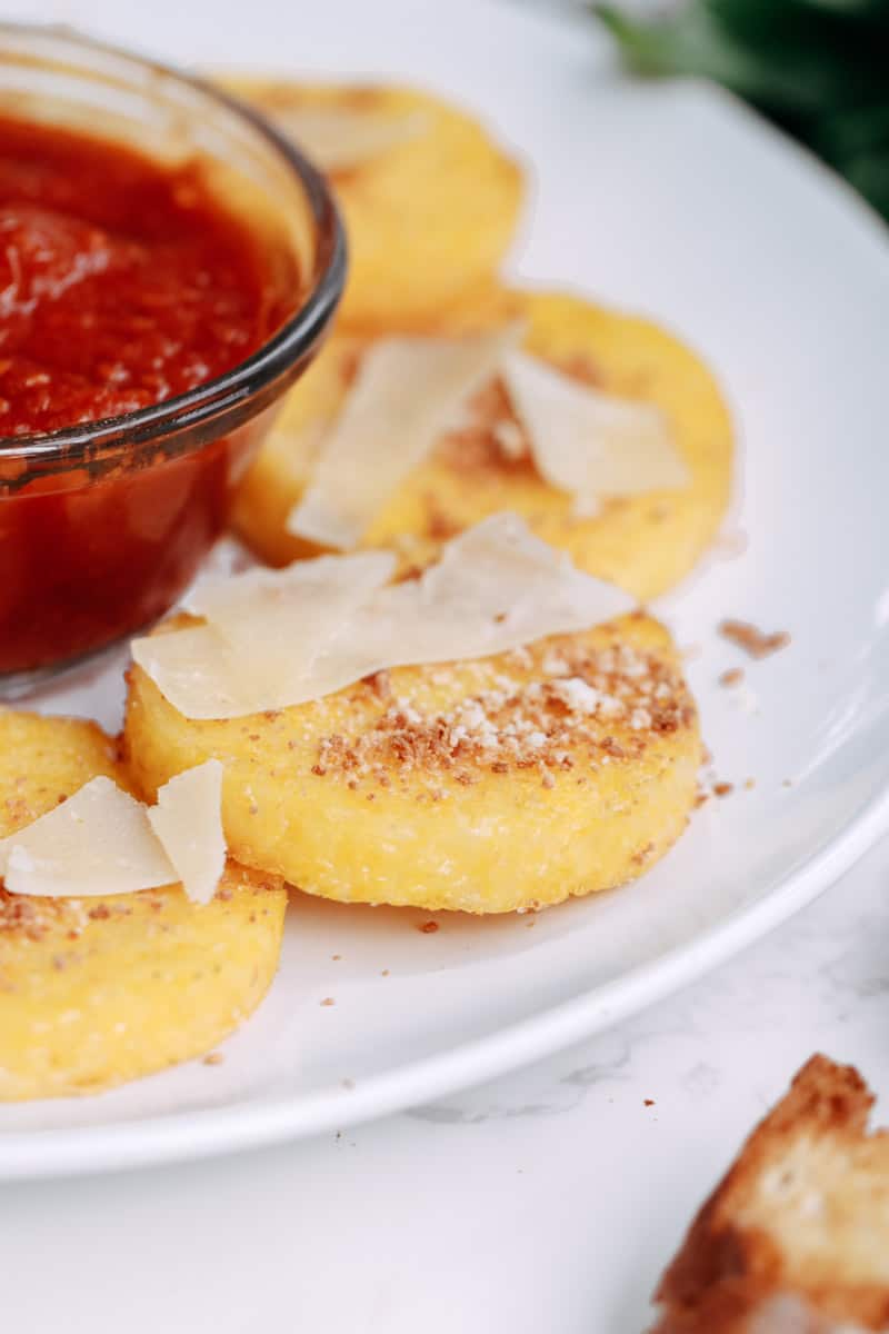 close up of polenta slices and marinara sauce.