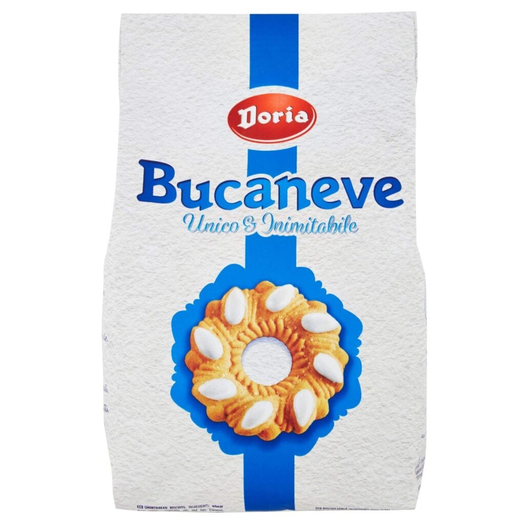 Photo of a bag of Doria Bucaneve Cookies (Bucaneve Line), clearly visible to highlight the packaging graphics and the cookies’ shape. It is possible to see through the window the interior of the bag and the cookies’ flower-shaped content. Doria brand, one of the historical companies of the Italian cookies industry, produces delicious and light-textured cookies, ideal for traditional Italian cookie brands lovers.