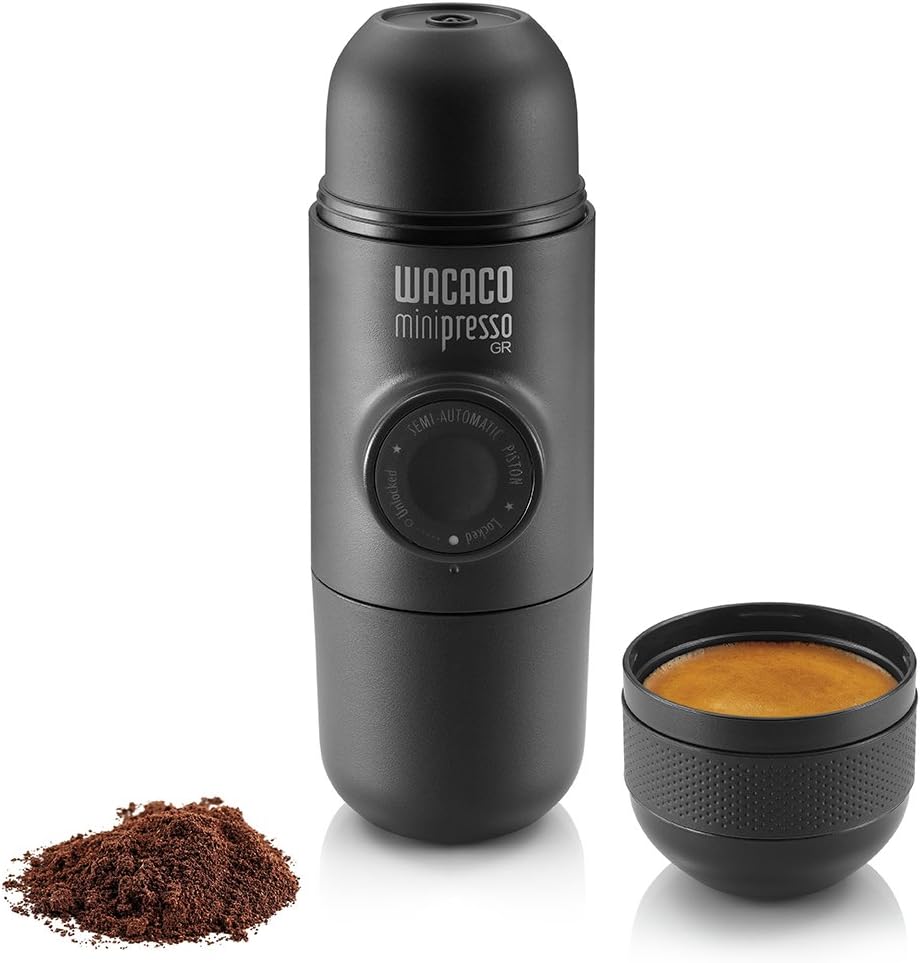 A high-resolution photograph of the WACACO Minipresso GR against a clean white background. This compact, portable espresso maker features a sleek, cylindrical design with a matte black finish and the WACACO logo subtly displayed. The Minipresso GR is designed for manual operation, with a built-in pump that allows you to prepare rich, high-quality espresso on the go. Its lightweight and ergonomic build make it ideal for traveling coffee makers, ensuring you can enjoy a fresh, barista-quality espresso wherever you are. Perfect for coffee lovers who prioritize convenience, portability, and excellent taste in their