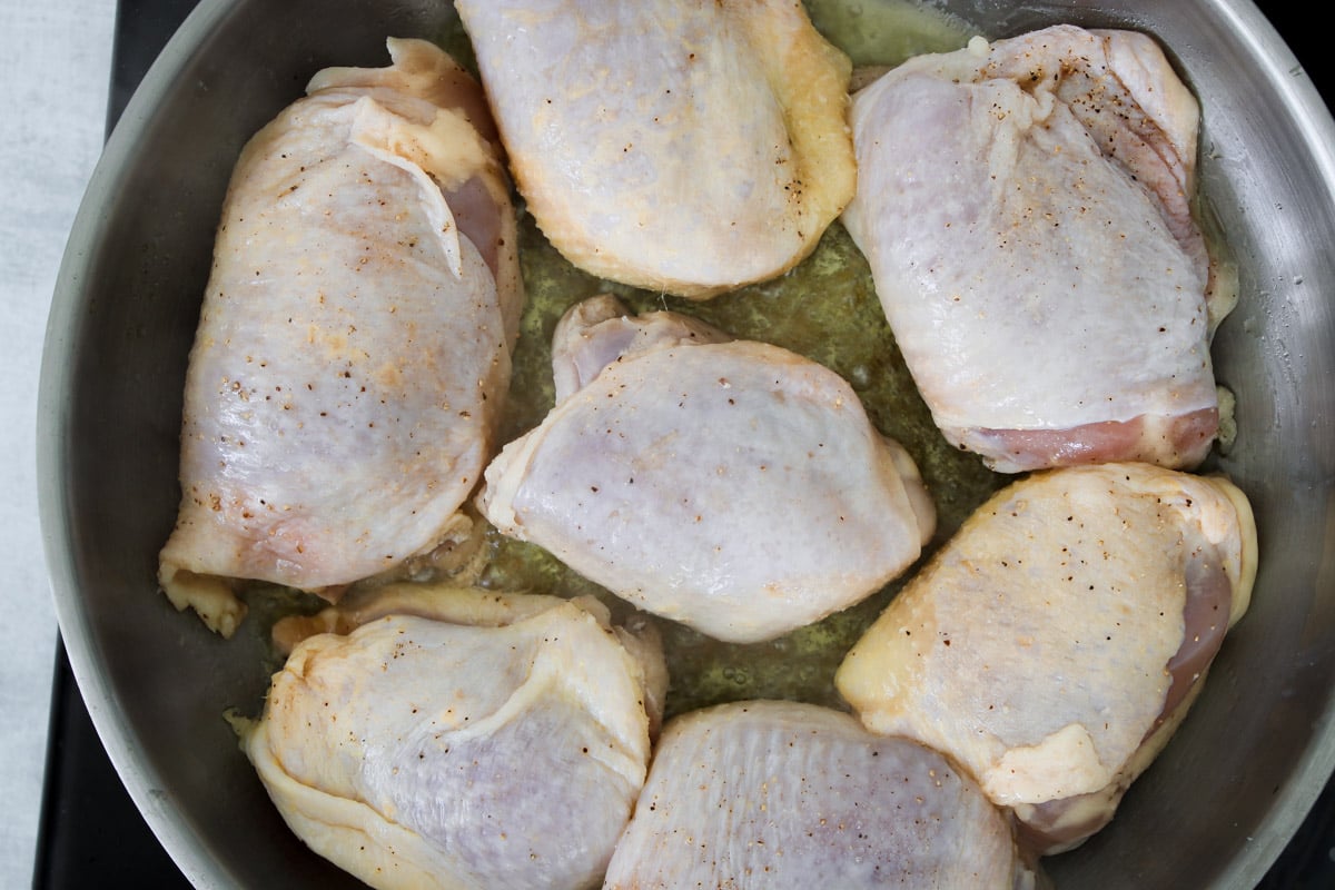 overhead image of cooking chicken in a skillet.