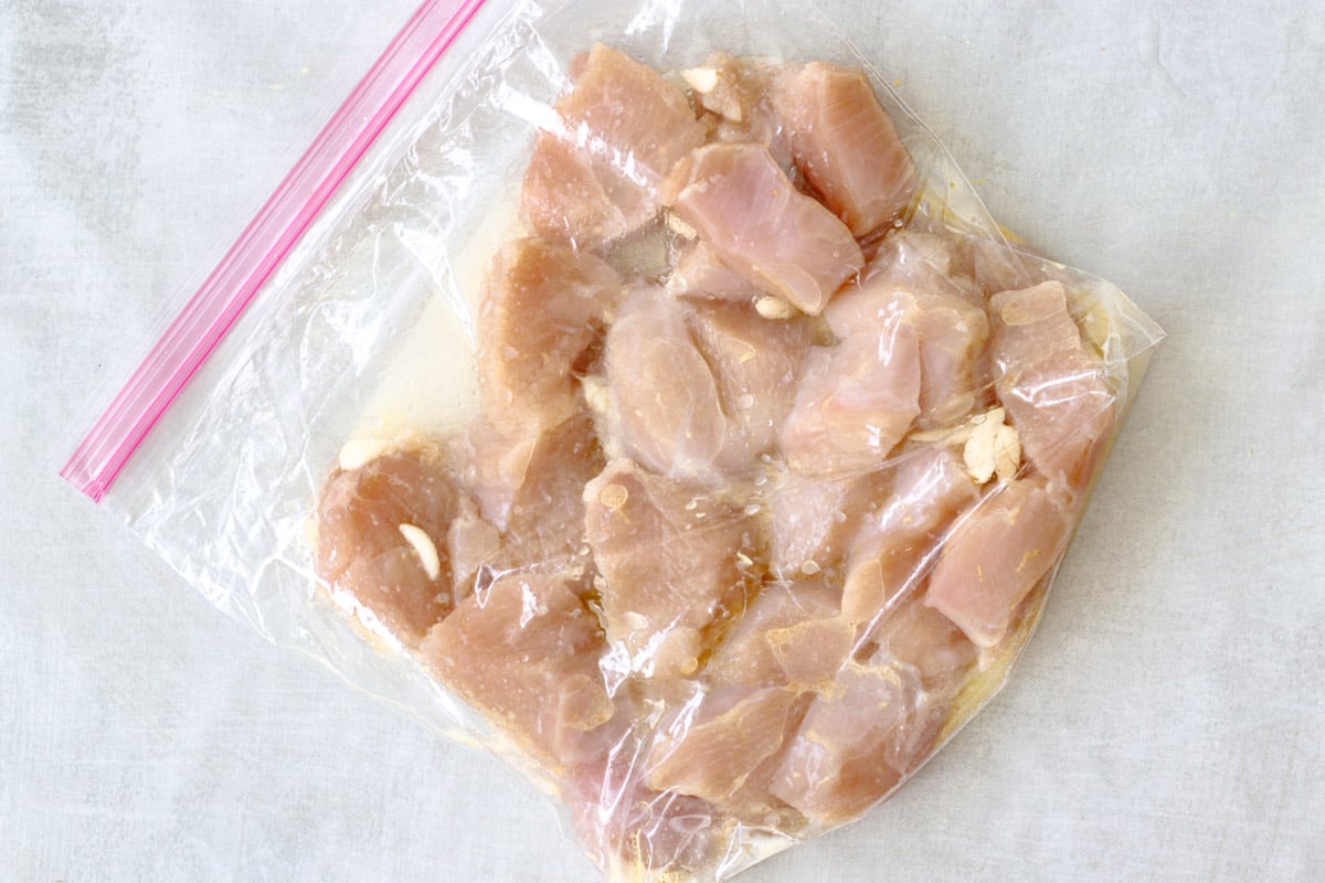 image of marinading chicken pieces in a large zipped lock bag.