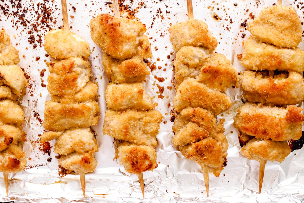 overhead image of chicken spiedini on a foil lined baking sheet.