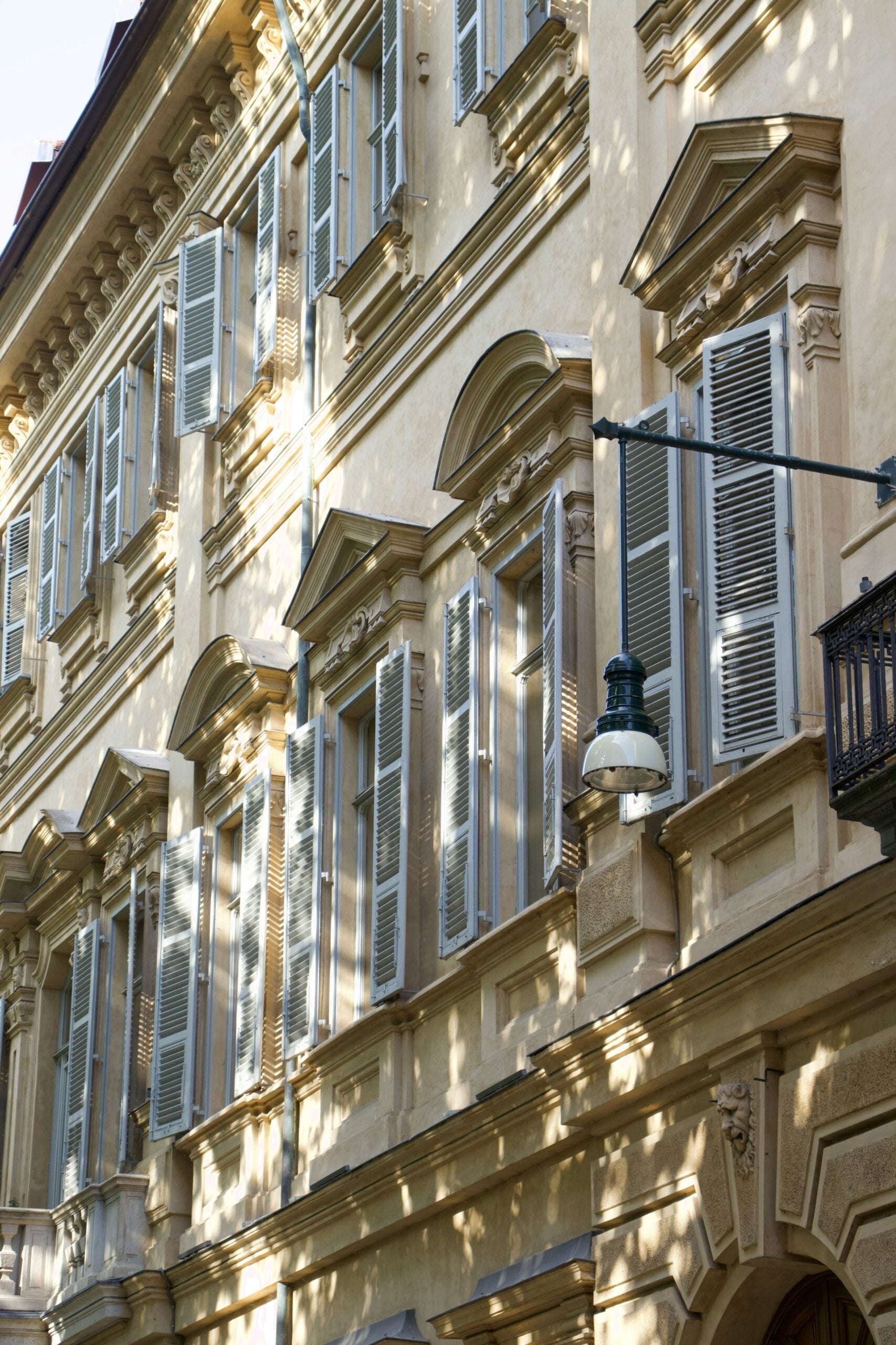 A cream-colored Baroque-inspired building facade stands elegantly in Turin, showcasing intricate architectural details that reflect the city's rich history and artistic heritage. The building's ornate carvings, grand windows, and decorative elements highlight the sophisticated design typical of Baroque architecture. Is Turin worth visiting? Absolutely! This stunning facade is just one example of the many beautiful and historically significant structures that make Turin a captivating destination for architecture enthusiasts and cultural travelers alike.