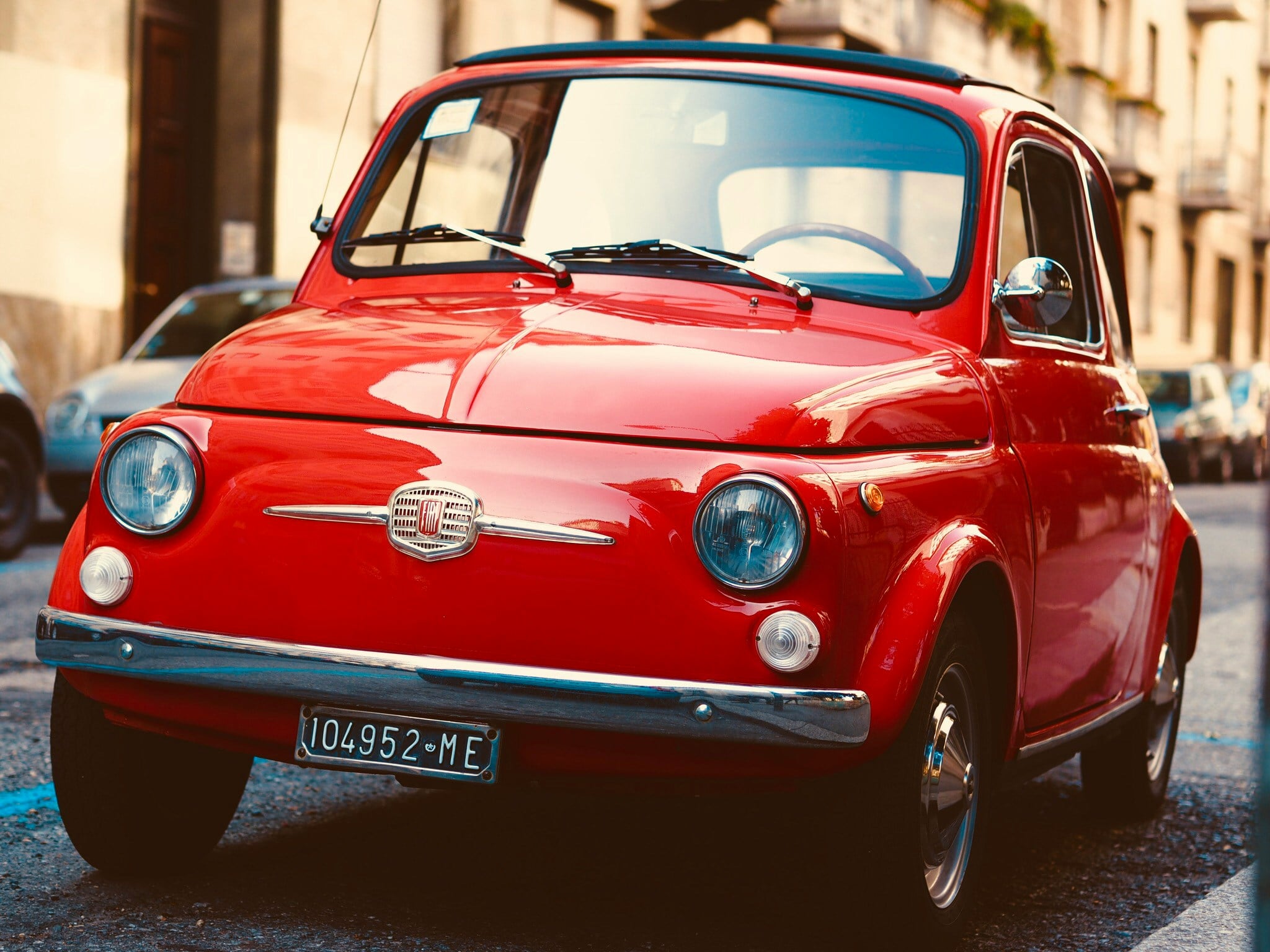 A pristine vintage red Fiat 500 is parked on a charming street in Turin, adding a touch of nostalgia to the urban landscape. The car's classic design and vibrant color stand out against the backdrop of Turin's historic buildings and cobblestone streets. Is Turin worth visiting? Absolutely! This iconic image encapsulates the timeless charm and unique character of Turin, making it a perfect destination for those who appreciate classic automobiles, rich history, and picturesque cityscapes.