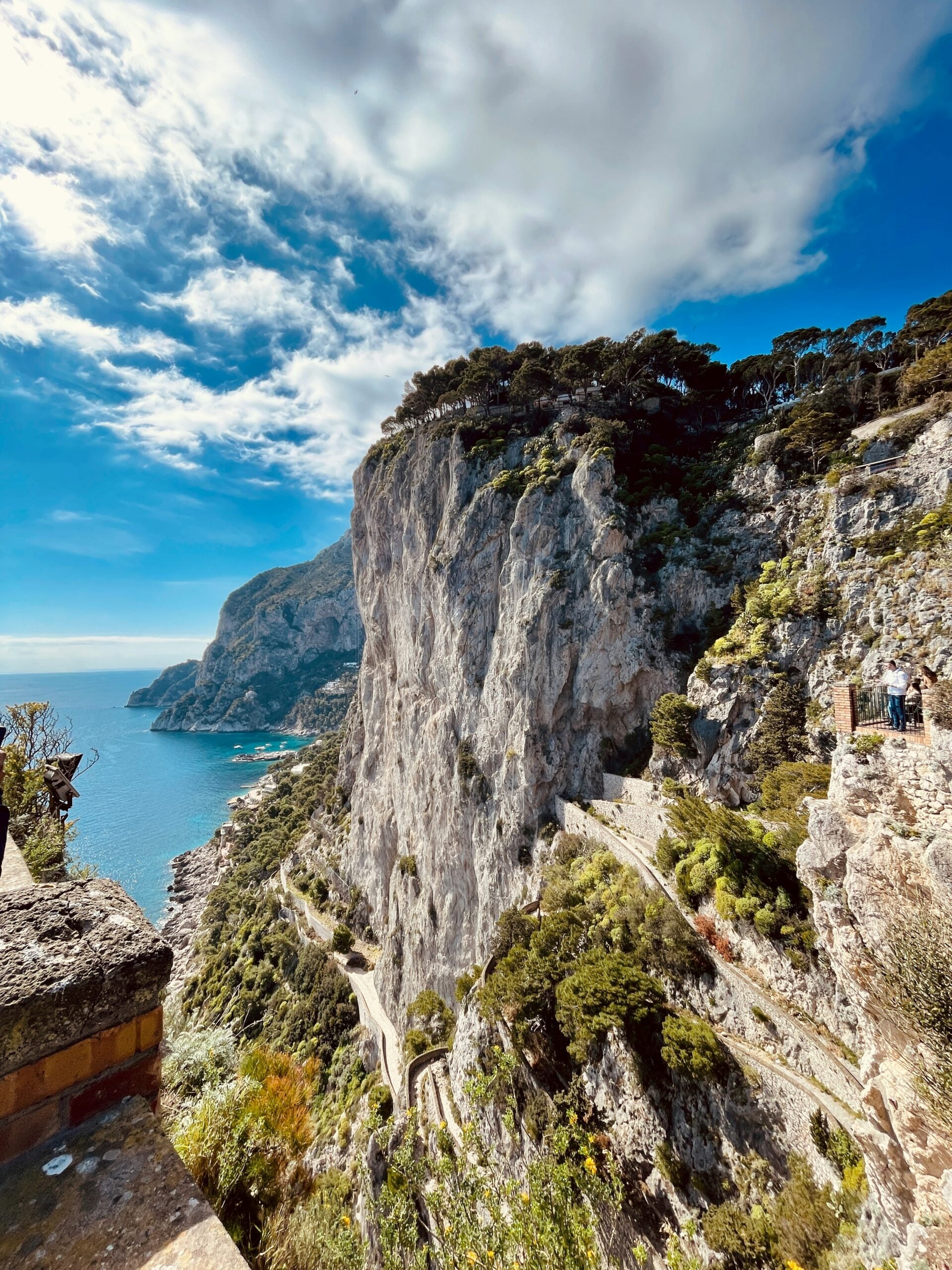A scenic view of Capri Island, Italy, featuring the azure sea from a side perspective of the steep cliffs. This captivating scene showcases the dramatic landscape of Capri Island, with its rugged cliffs plunging into the crystal-clear waters of the Mediterranean. The panoramic vista highlights the natural beauty and serene coastal allure of Capri Island, making it a quintessential destination for travelers seeking breathtaking seascapes and stunning cliffside views.
