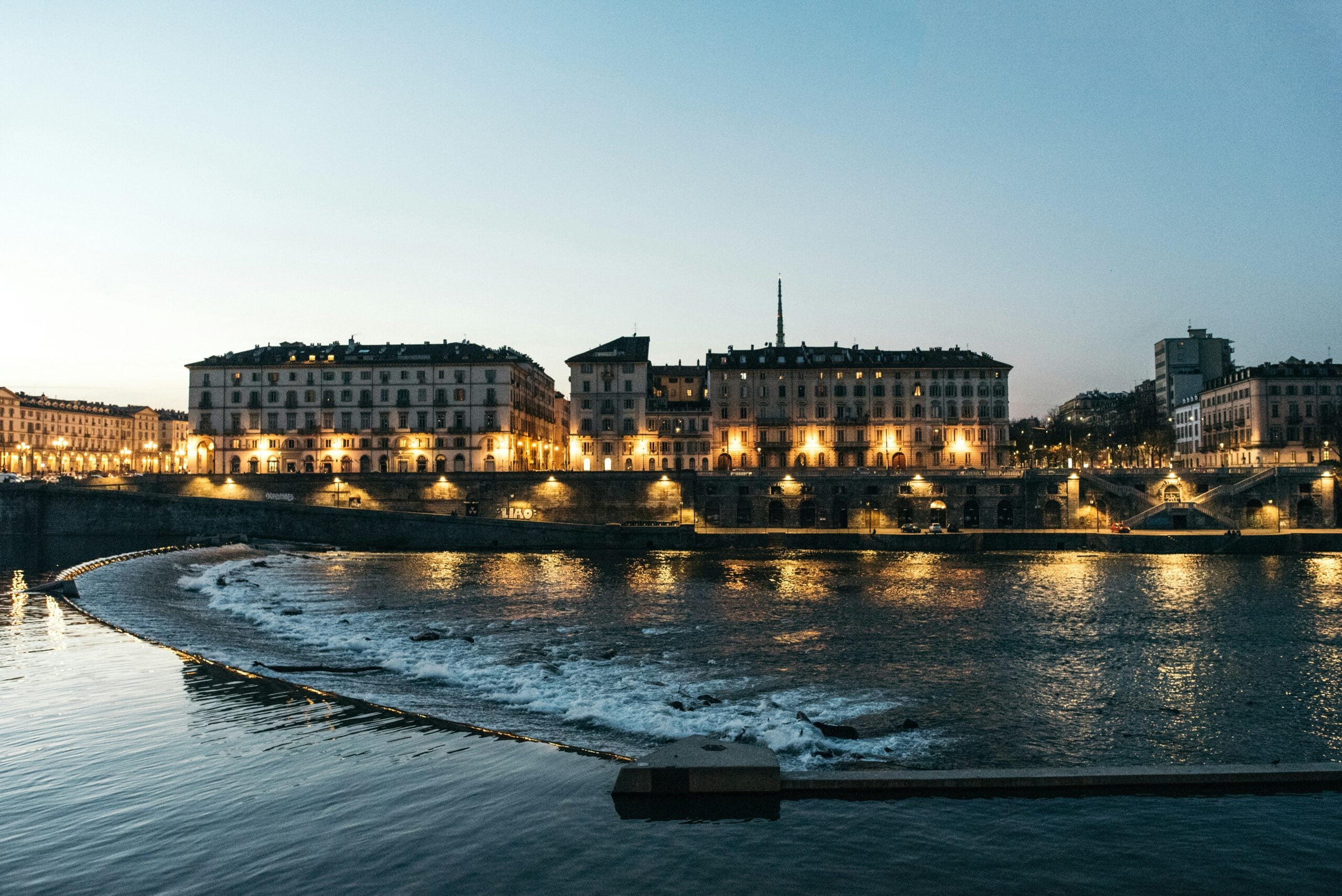 Turin's city lights twinkle in the early morning, casting a magical glow along the riverbank. The serene waters of the Po River reflect the shimmering lights, creating a captivating and tranquil scene. The city's elegant architecture, bridges, and tree-lined pathways are softly illuminated, adding to the enchanting ambiance. Is Turin worth visiting? Absolutely! This picturesque moment captures the serene beauty and charm of Turin, making it a must-visit destination for those who appreciate the tranquility and allure of a city at dawn.