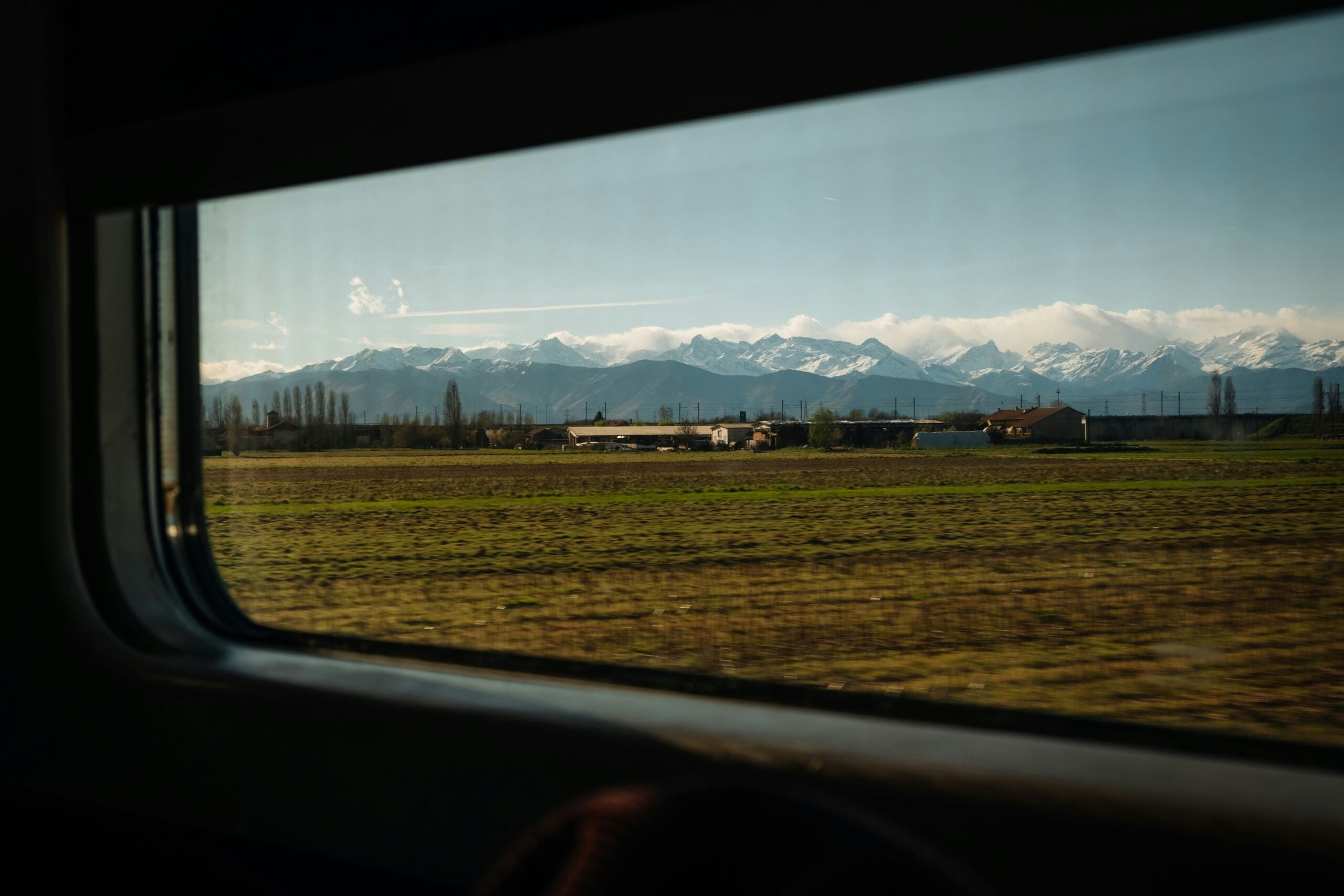 A view of the Piemonte landscape from a train captures the serene beauty of rolling hills, lush vineyards, and quaint villages. The verdant scenery is interspersed with charming farmhouses and dotted with rows of grapevines, reflecting the region's rich agricultural heritage. Is Turin worth visiting? Absolutely! This picturesque train journey through the Piemonte countryside highlights the natural beauty and cultural richness that make Turin and its surrounding areas an idyllic destination for travelers seeking a tranquil and scenic escape.