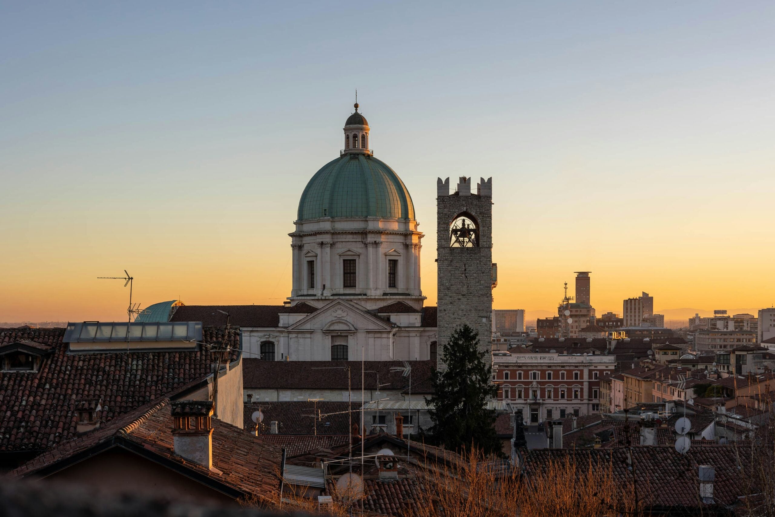 Photograph of Brescia Cathedral at sunset, highlighting the magnificent dome against the vibrant hues of the evening sky. Located in the Lombardy region, this image captures the striking architecture and serene atmosphere of one of Brescia's most revered landmarks, offering a mesmerizing view that attracts both tourists and photography enthusiasts.