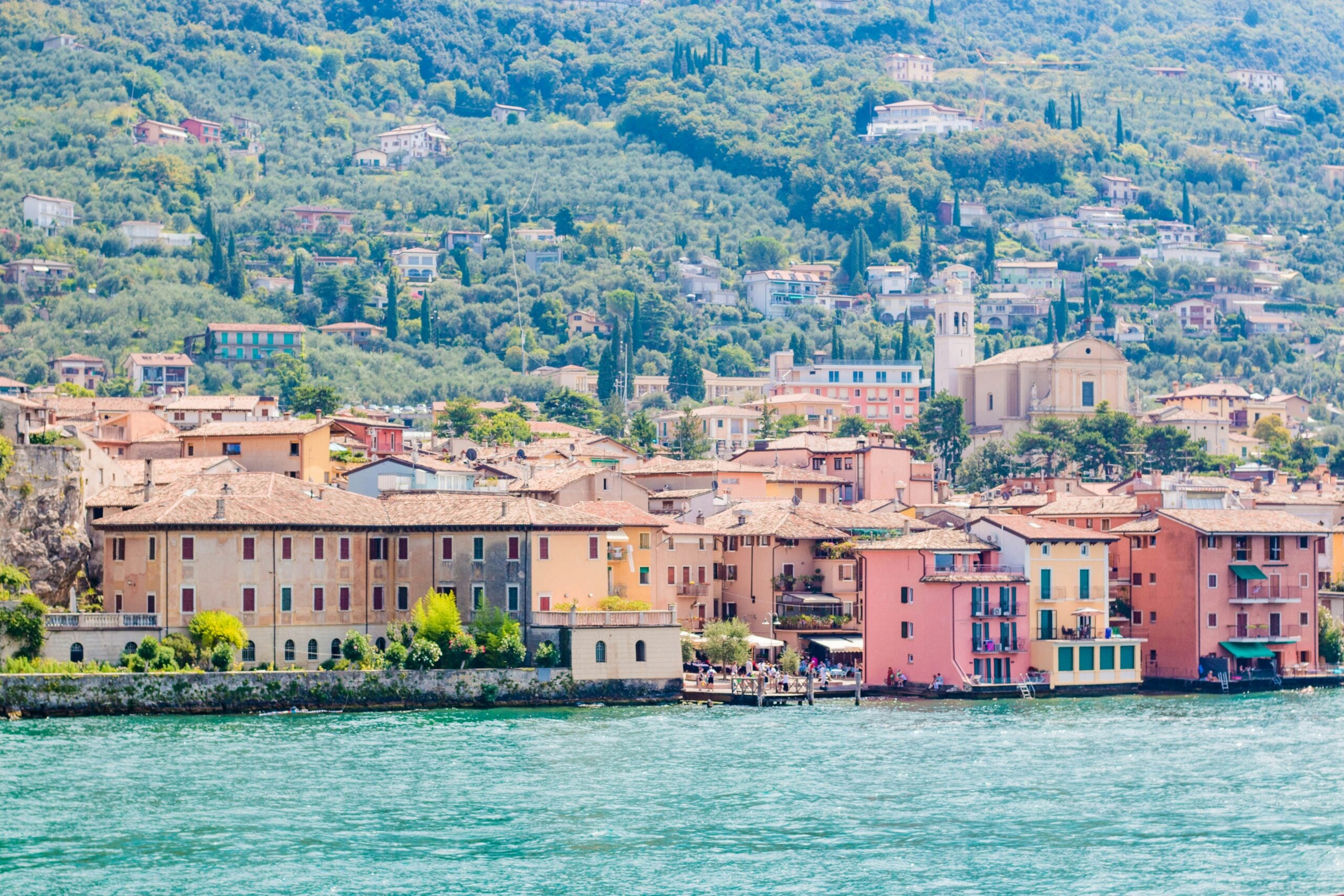 Photograph of Limone Sul Garda in the Province of Brescia, Italy, capturing the charming lakeside town nestled against dramatic mountain backdrops. The image features the quaint streets, colorful buildings, and the serene waters of Lake Garda, illustrating a perfect blend of natural beauty and quaint village life. Ideal for travelers drawn to picturesque settings and tranquil lake views.