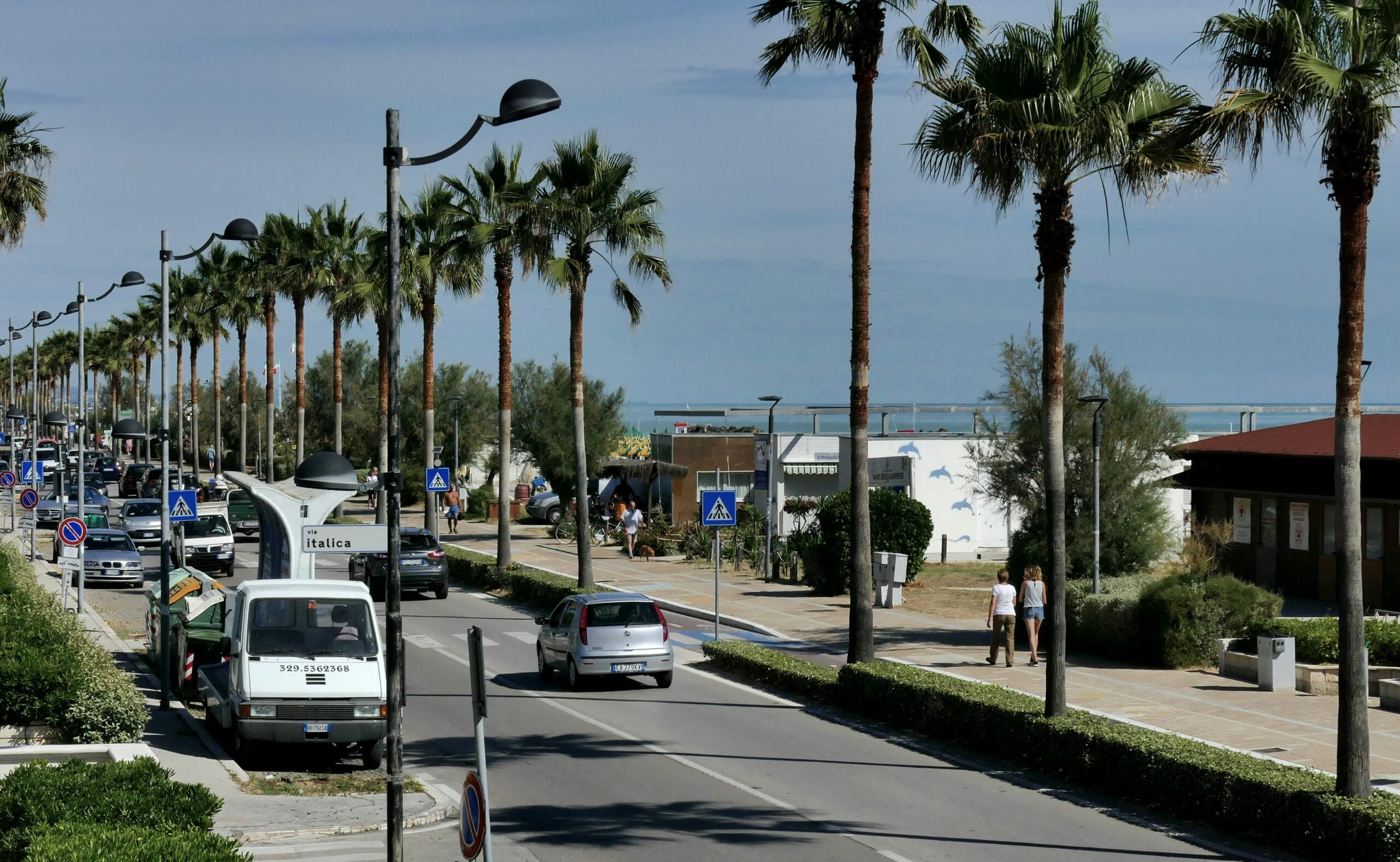 The main promenade in Pescara, Italy, known as Lungomare Matteotti, runs parallel to the beach, offering a picturesque blend of coastal and urban scenery. This wide, tree-lined boulevard is bustling with activity, featuring a dedicated walkway for pedestrians, a cycling path, and benches for relaxing and taking in the views. On one side, the Adriatic Sea stretches out with its inviting sandy beaches, while on the other, the promenade is flanked by a variety of cafes, restaurants, and shops. The road is often filled with locals and tourists enjoying the vibrant atmosphere, with the sound of waves in the background. This iconic stretch in Pescara encapsulates the lively yet laid-back coastal lifestyle that the city is known for.
