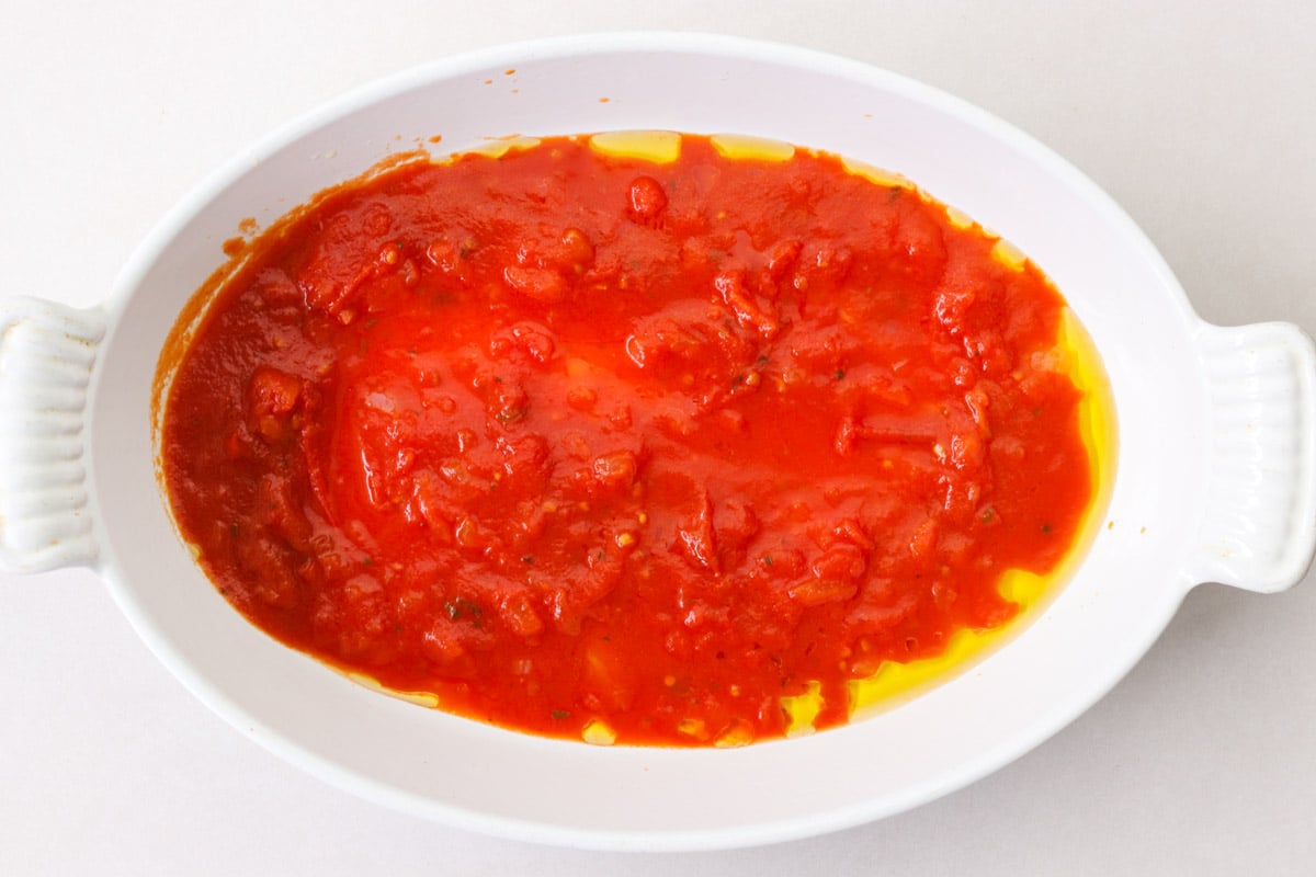 overhead image of sauce in a white casserole for eggplant parmesan.
