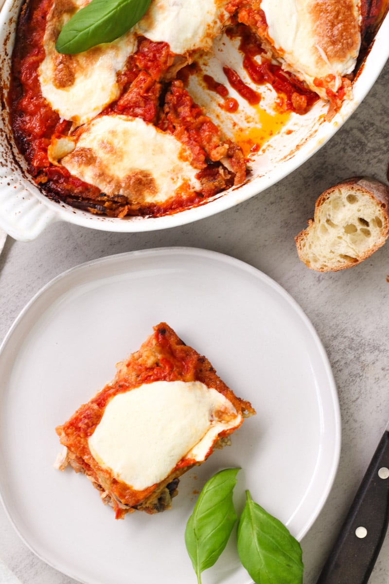 overhead image of Parmigiana di Melanzane (Traditional Eggplant Parmigiana)in a white casserole.