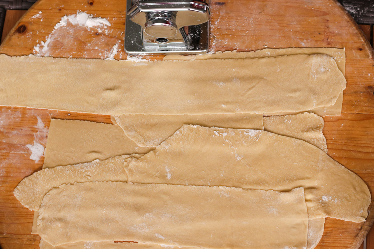 overhead image of pasta sheets on a wooden board.